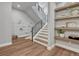 Hallway featuring a staircase with sleek railing, wood floors, and decorative floating shelves at 2690 Fox View Trl, Franktown, CO 80116