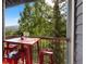 Inviting balcony with a red metal table and chairs and with scenic views of the lush greenery at 100 S Park Ave # E321, Breckenridge, CO 80424