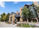 Grand entrance to River Mountain Lodge featuring a glass awning, brick columns, and colorful landscaping at 100 S Park Ave # E321, Breckenridge, CO 80424