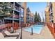 Community pool with lounge chairs, fencing, and multiple story condos surrounding at 100 S Park Ave # E321, Breckenridge, CO 80424