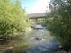 Scenic river view flowing under the community bridge, surrounded by lush greenery and a bright blue sky at 100 S Park Ave # E321, Breckenridge, CO 80424