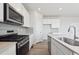 Modern kitchen boasts stainless steel appliances, white cabinets, and quartz countertops at 9992 Racine St, Commerce City, CO 80022