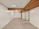 Spacious basement with carpet flooring, wood beams, and paneled walls offers a versatile living space at 6800 Fern Dr, Denver, CO 80221