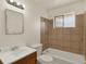 Standard bathroom featuring tiled shower-tub combo, single sink vanity, and window at 6800 Fern Dr, Denver, CO 80221