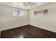Bright bedroom with hardwood floors, two large windows providing ample natural light, and neutral walls at 6800 Fern Dr, Denver, CO 80221