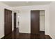 Open bedroom featuring hardwood floors, a closet, and an open doorway at 6800 Fern Dr, Denver, CO 80221