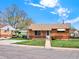 Charming brick home featuring a tidy front yard and inviting facade under a bright sky at 6800 Fern Dr, Denver, CO 80221