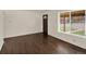Bright living room featuring newly refinished dark hardwood floors and a large window with ample sunlight at 6800 Fern Dr, Denver, CO 80221