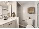 Bright bathroom features updated vanity with black hardware, modern fixtures, shower, and built-in storage at 6800 E Tennessee Ave # 111, Denver, CO 80224
