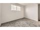 Empty bedroom with gray carpet, a window, and white walls provides a blank canvas at 6800 E Tennessee Ave # 111, Denver, CO 80224
