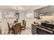 Eat-in kitchen features modern light fixture, table, and gray cabinets with stainless appliances at 6800 E Tennessee Ave # 111, Denver, CO 80224