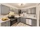 Updated kitchen featuring stainless steel appliances, modern gray cabinets, and marble backsplash at 6800 E Tennessee Ave # 111, Denver, CO 80224