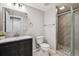 Bathroom featuring dark cabinets, modern fixtures, and tiled shower at 1551 Northridge Dr, Highlands Ranch, CO 80126