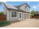 Attractive two-story home featuring gray siding, solar panels, a two-car garage, and a landscaped front at 1551 Northridge Dr, Highlands Ranch, CO 80126