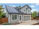 Charming gray two-story home featuring solar panels, a two-car garage, and a well-maintained front yard at 1551 Northridge Dr, Highlands Ranch, CO 80126