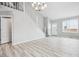 Spacious and bright living room with light wood floors, a white staircase, and natural light at 1551 Northridge Dr, Highlands Ranch, CO 80126