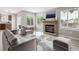 Bright living room with a brick fireplace, large windows, stylish furniture, and contemporary decor at 1551 Northridge Dr, Highlands Ranch, CO 80126
