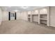 Large finished basement with neutral carpet, recessed lighting, and built-in shelving at 23420 E Berry Ave, Aurora, CO 80016
