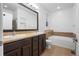 Bright bathroom featuring double sinks, soaking tub, and tiled floors at 23420 E Berry Ave, Aurora, CO 80016