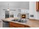 Close up of the kitchen sink, faucet, dishwasher, and view into living room with fireplace at 23420 E Berry Ave, Aurora, CO 80016