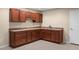 Basement kitchenette features wood cabinets, light countertops, and stainless steel sink at 23420 E Berry Ave, Aurora, CO 80016