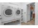 Convenient laundry room with modern washer and dryer, shelving, and tile floors at 23420 E Berry Ave, Aurora, CO 80016