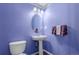 Quaint powder room featuring a pedestal sink, oval mirror, and bright purple walls at 10554 Atwood Cir, Littleton, CO 80130