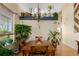 Warm dining area with wooden table, decorative chandelier, and shelving with plants at 10554 Atwood Cir, Littleton, CO 80130