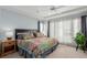 Bright main bedroom with a decorative quilt, tray ceiling, and large window at 10554 Atwood Cir, Littleton, CO 80130