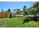 Well-maintained backyard features a storage shed, lush lawn, and beautiful landscaping at 15440 E Oberlin Pl, Aurora, CO 80013