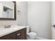 Well-appointed half-bathroom with a dark vanity, modern fixtures, and a framed mirror at 15440 E Oberlin Pl, Aurora, CO 80013