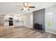 Bright living room featuring a brick fireplace, ceiling fan, and modern vinyl flooring at 15440 E Oberlin Pl, Aurora, CO 80013