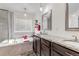 Bright bathroom featuring a soaking tub, granite counters, and modern fixtures at 697 Sundance Cir, Erie, CO 80516