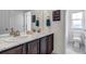 Bathroom featuring double sink vanity, marble countertop, and toilet in separate room at 697 Sundance Cir, Erie, CO 80516