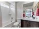 Bright bathroom features a shower and tub combination, marble countertop, dark wood cabinets and a mirror at 697 Sundance Cir, Erie, CO 80516