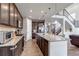 Modern kitchen with granite countertops, dark wood cabinets, and stainless steel appliances plus eat-in dining area at 697 Sundance Cir, Erie, CO 80516