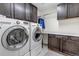 Functional laundry room featuring front loading washer and dryer and built in cabinets and countertop at 697 Sundance Cir, Erie, CO 80516