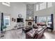 Bright living room with soaring ceilings, a modern fireplace, hardwood floors, and ample natural light at 697 Sundance Cir, Erie, CO 80516
