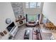 Sun-filled living room featuring a stacked stone fireplace, high ceilings, and hardwood floors at 697 Sundance Cir, Erie, CO 80516