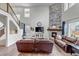 Open-concept living area with a stone fireplace, hardwood floors, and a staircase with iron railings at 697 Sundance Cir, Erie, CO 80516