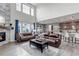 Open living area with hardwood floors, a stone fireplace, and an adjacent kitchen with a breakfast bar at 697 Sundance Cir, Erie, CO 80516
