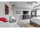 Spacious primary bedroom with sitting area, tray ceiling, fan, neutral color palette and natural light at 697 Sundance Cir, Erie, CO 80516
