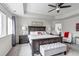 Spacious primary bedroom with a tray ceiling, ceiling fan, bench, and large windows at 697 Sundance Cir, Erie, CO 80516