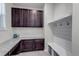 Functional mudroom features dark cabinets, granite countertops, and coat hooks at 697 Sundance Cir, Erie, CO 80516
