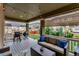 Relaxing covered patio area equipped with a grill, comfortable sofa, and outdoor furniture at 697 Sundance Cir, Erie, CO 80516