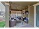Inviting covered patio features comfortable seating, stylish rug, and ambient string lights at 697 Sundance Cir, Erie, CO 80516