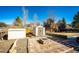 Backyard featuring a brick patio with fire pit, shed and mature trees at 11 Gordon Dr, Castle Rock, CO 80104