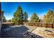Enjoy this private backyard featuring mature trees, brick-paved area with firepit, and a privacy fence at 11 Gordon Dr, Castle Rock, CO 80104