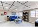 Finished basement with a blue sofa, coffee table, bookshelf, and a well-lit recreation area at 4010 S Rifle Way, Aurora, CO 80013