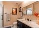 Bathroom showcasing a dark vanity, marble countertop, framed artwork, and glass-enclosed shower at 4010 S Rifle Way, Aurora, CO 80013